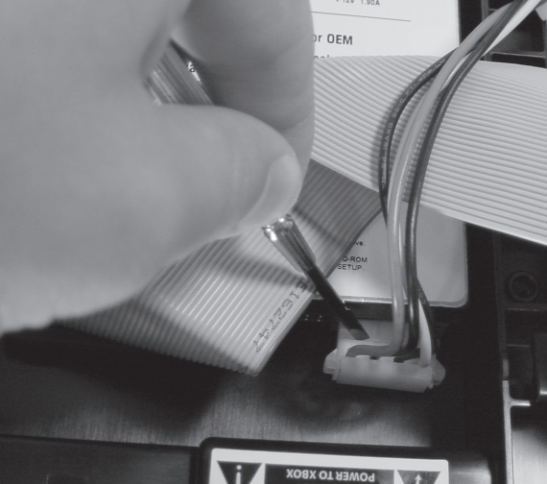 Figure 1-9: Prying the hard drive power connector off with a flathead screwdriver.